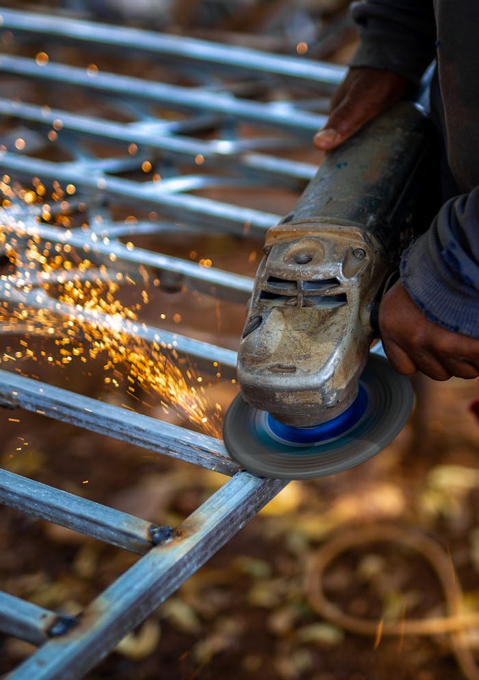 pexels-photo-29386086 Close-up of a worker using a grinder on metal, creating a shower of sparks.